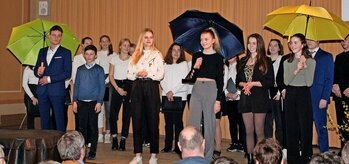 Die Besucher werden von Guides mit bunten Regenschirmen durch das Gymnasium geführt. Die stellten sich zuvor in der Aula vor